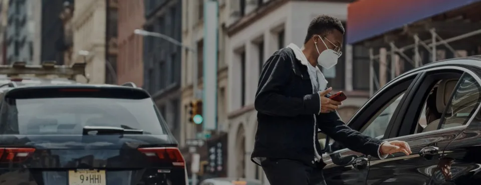Driver checking a phone beside a car